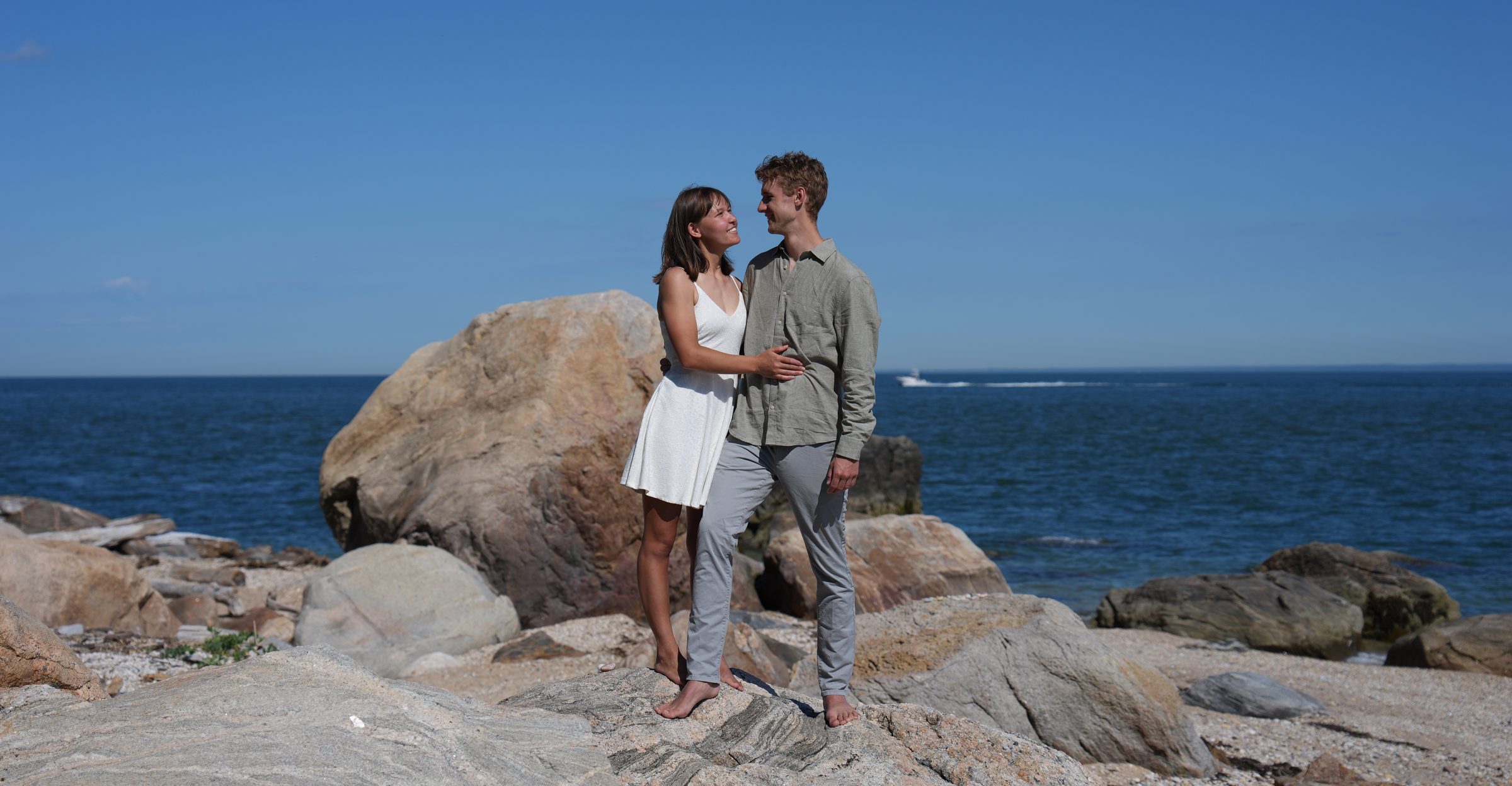 Scott and Christina standing together on the rocks by the Long Island Sound